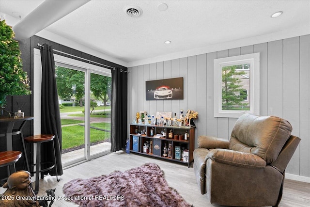 3707 W Michigan Ave, Lansing, MI 48917 - living area featuring healthy amount of natural light, wood finished floors, a textured ceiling, and recessed lighting