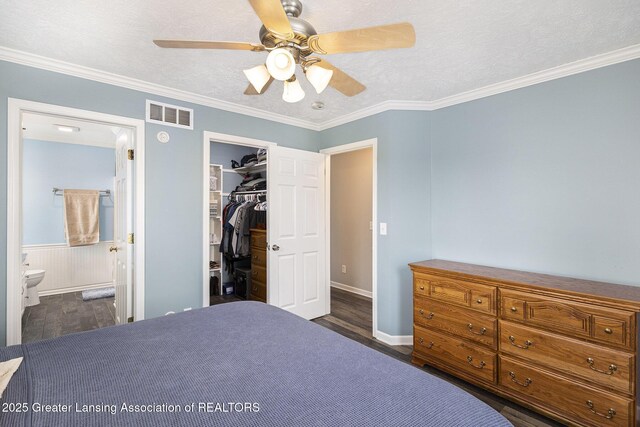 491 Anhinga Dr, East Lansing, MI 48823 - bedroom with dark wood-style floors, crown molding, a spacious closet, a closet, and ensuite bathroom