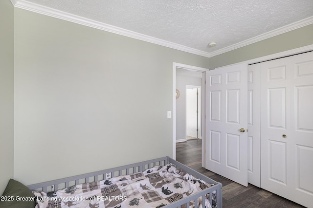 491 Anhinga Dr, East Lansing, MI 48823 - bedroom with dark wood finished floors, ornamental molding, a textured ceiling, and a closet