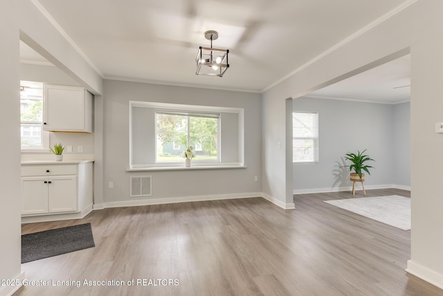 1041 Parker St, Lansing, MI 48912 - unfurnished dining area featuring plenty of natural light, light wood-type flooring, and ornamental molding