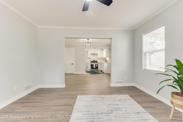 1041 Parker St, Lansing, MI 48912 - living room with a ceiling fan, crown molding, light wood-style floors, and a chandelier