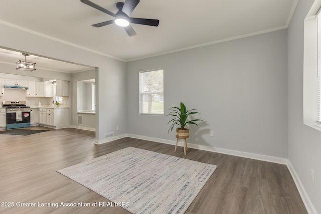 1041 Parker St, Lansing, MI 48912 - living area with wood finished floors, crown molding, and ceiling fan