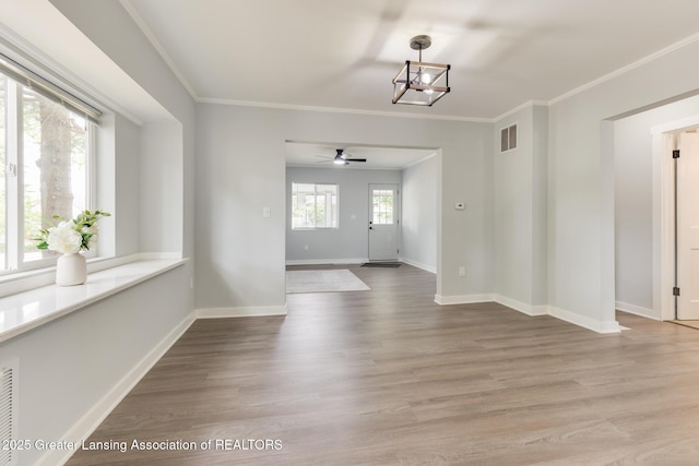 1041 Parker St, Lansing, MI 48912 - unfurnished dining area featuring a ceiling fan, a chandelier, light wood finished floors, and ornamental molding
