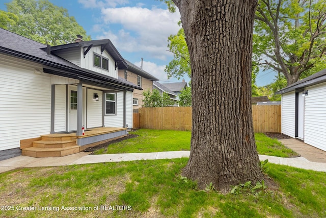 1041 Parker St, Lansing, MI 48912 - view of front of house with covered porch, a fenced backyard, and a chimney