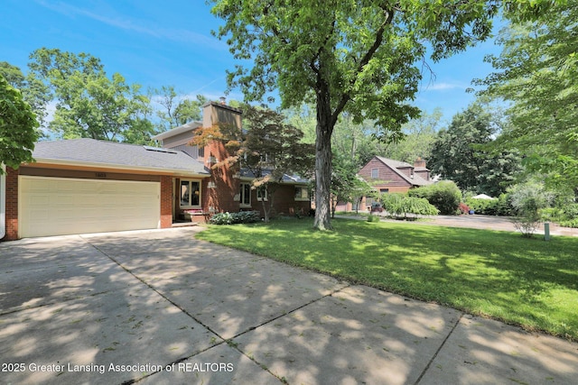 1603 Roseland Ave, East Lansing, MI 48823 - view of front facade with brick siding, a front yard, concrete driveway, and a garage