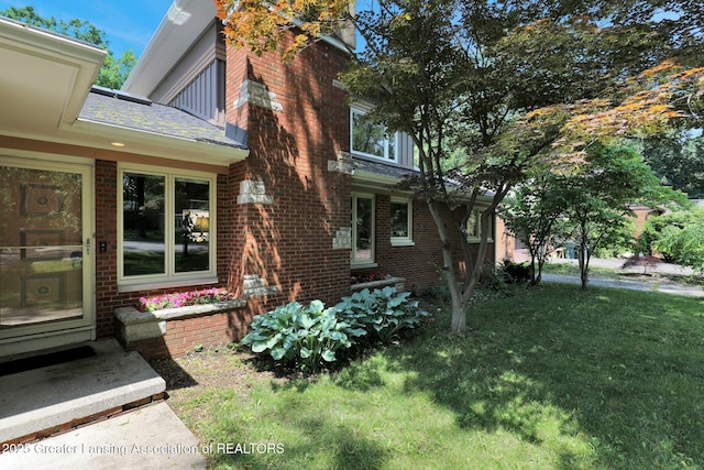 1603 Roseland Ave, East Lansing, MI 48823 - view of home's exterior featuring brick siding, a yard, and a shingled roof