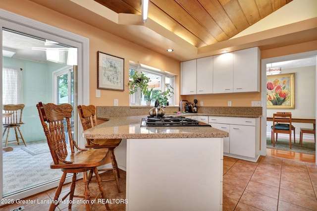 1603 Roseland Ave, East Lansing, MI 48823 - kitchen featuring stainless steel gas cooktop, a peninsula, wooden ceiling, healthy amount of natural light, and white cabinets