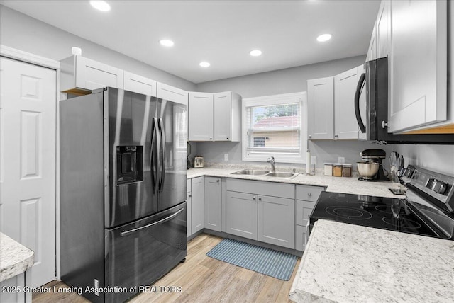2914 W Holmes Rd, Lansing, MI 48911 - kitchen featuring stainless steel appliances, light countertops, light wood finished floors, and recessed lighting