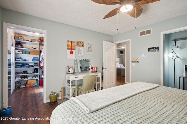 1234 Lamb Rd, Mason, MI 48854 - bedroom with a walk in closet, wood finished floors, a closet, a ceiling fan, and a textured ceiling