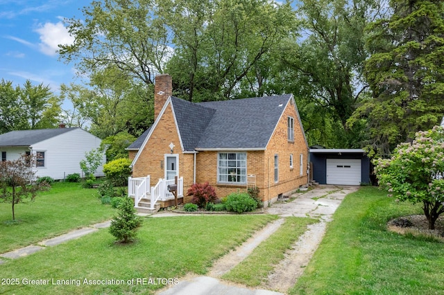 229 Rockingham Ave, Alma, MI 48801 - view of front facade with driveway, a shingled roof, brick siding, a front yard, and a chimney