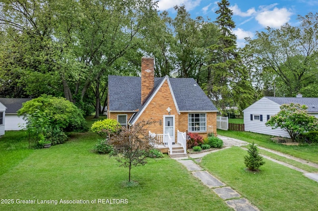 229 Rockingham Ave, Alma, MI 48801 - view of front facade with a chimney, brick siding, and roof with shingles