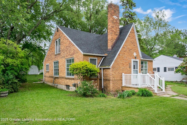 229 Rockingham Ave, Alma, MI 48801 - back of house featuring brick siding, a lawn, a chimney, and a shingled roof