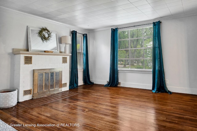 229 Rockingham Ave, Alma, MI 48801 - unfurnished living room featuring ornamental molding, wood finished floors, and a brick fireplace