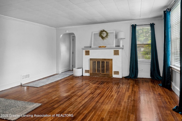 229 Rockingham Ave, Alma, MI 48801 - unfurnished living room with arched walkways, a fireplace, hardwood / wood-style floors, and ornamental molding