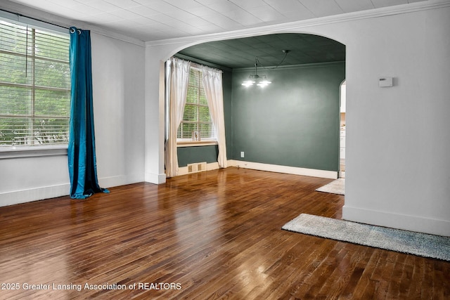 229 Rockingham Ave, Alma, MI 48801 - unfurnished room featuring arched walkways, crown molding, and hardwood / wood-style floors