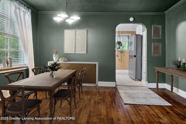 229 Rockingham Ave, Alma, MI 48801 - dining room with arched walkways, ornamental molding, wood-type flooring, and a chandelier