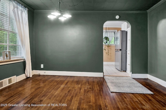 229 Rockingham Ave, Alma, MI 48801 - spare room with arched walkways, hardwood / wood-style flooring, ornamental molding, and a chandelier