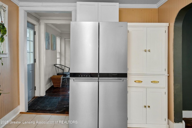 229 Rockingham Ave, Alma, MI 48801 - kitchen featuring freestanding refrigerator, arched walkways, crown molding, white cabinetry, and light tile patterned floors