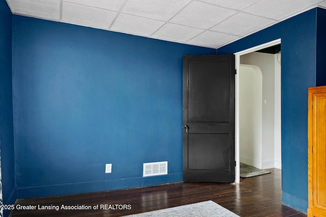 229 Rockingham Ave, Alma, MI 48801 - spare room featuring wood finished floors, a paneled ceiling, and arched walkways