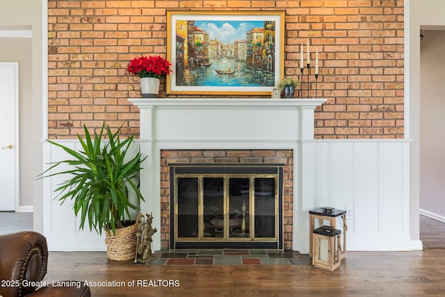 1717 Nottingham Rd, Lansing, MI 48911 - detailed view of a fireplace, wood finished floors, wainscoting, and brick wall