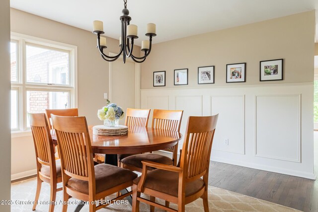 1717 Nottingham Rd, Lansing, MI 48911 - dining area featuring a chandelier, a decorative wall, wood finished floors, and wainscoting