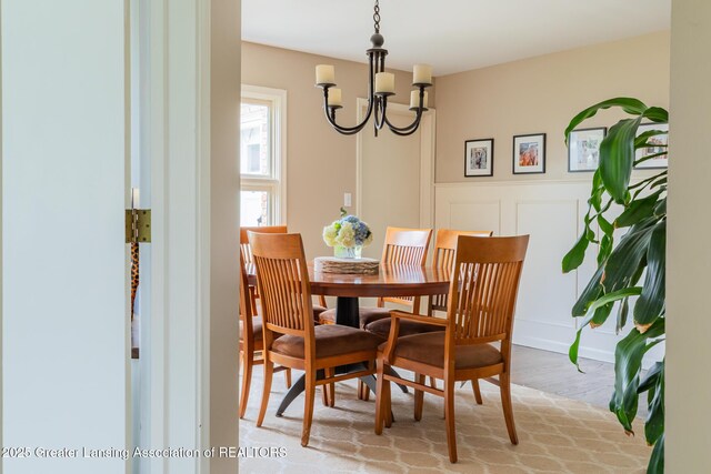 1717 Nottingham Rd, Lansing, MI 48911 - dining area featuring a decorative wall, a chandelier, light wood-type flooring, and a wainscoted wall
