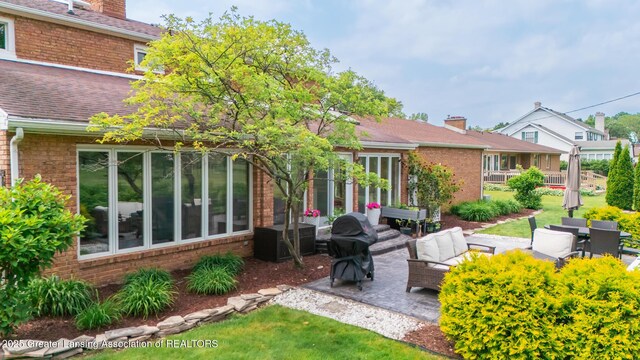 1717 Nottingham Rd, Lansing, MI 48911 - rear view of property with a patio area, a chimney, brick siding, and outdoor lounge area