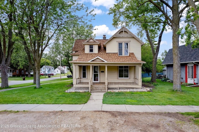 301 E Emerson St, Ithaca, MI 48847 - victorian home featuring covered porch, a shingled roof, a front yard, and a chimney
