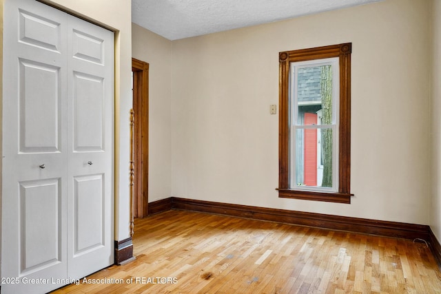 301 E Emerson St, Ithaca, MI 48847 - unfurnished room featuring light wood-style flooring and a textured ceiling