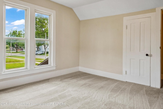 301 E Emerson St, Ithaca, MI 48847 - carpeted empty room featuring vaulted ceiling and baseboards