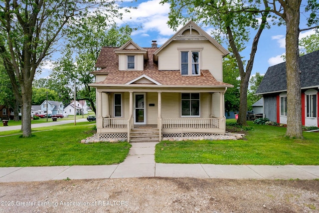 301 E Emerson St, Ithaca, MI 48847 - victorian house featuring a shingled roof, a front lawn, and covered porch