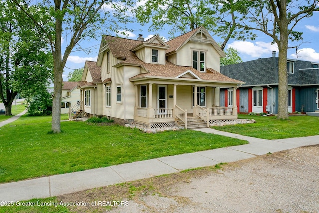 301 E Emerson St, Ithaca, MI 48847 - victorian-style house featuring a porch, a front lawn, roof with shingles, and a chimney