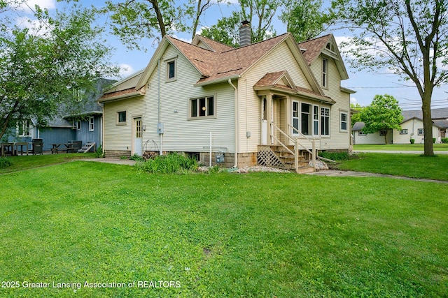 301 E Emerson St, Ithaca, MI 48847 - view of front of property with entry steps, a chimney, a front lawn, and a shingled roof