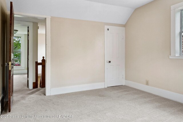 301 E Emerson St, Ithaca, MI 48847 - unfurnished room with carpet flooring and lofted ceiling