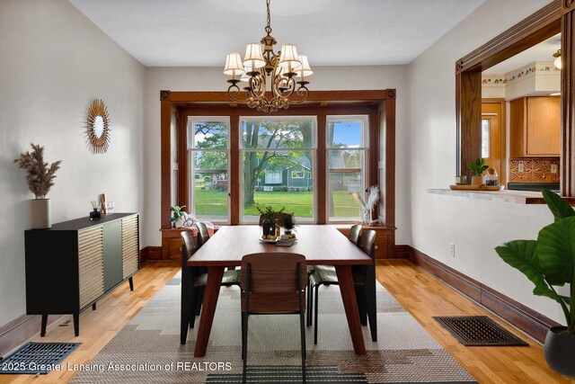 301 E Emerson St, Ithaca, MI 48847 - dining area featuring light wood-style flooring and a chandelier