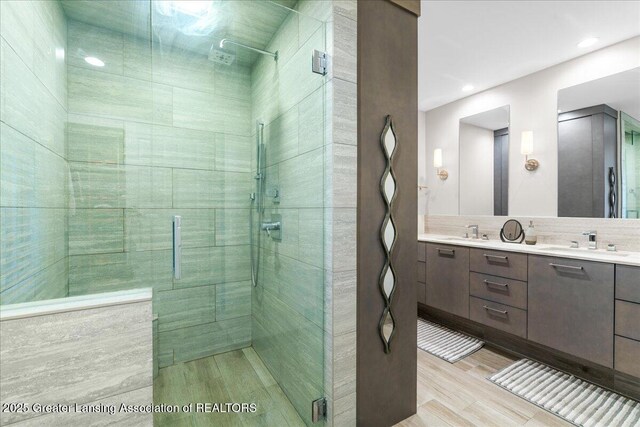 3886 Hemmingway Dr, Okemos, MI 48864 - bathroom with a stall shower, wood finished floors, double vanity, recessed lighting, and backsplash
