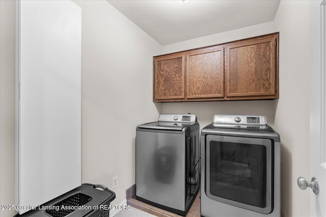 3886 Hemmingway Dr, Okemos, MI 48864 - washroom with washer and clothes dryer, cabinet space, and light tile patterned floors