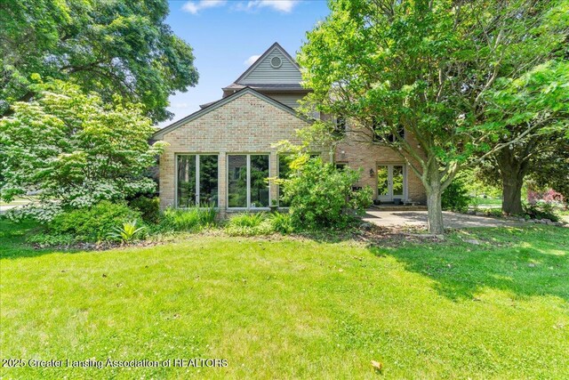 3886 Hemmingway Dr, Okemos, MI 48864 - view of front of house with a front lawn, brick siding, and french doors
