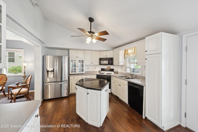 15754 Culver Dr, East Lansing, MI 48823 - kitchen with black appliances, vaulted ceiling, a ceiling fan, white cabinetry, and a kitchen island