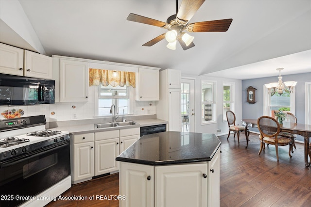 15754 Culver Dr, East Lansing, MI 48823 - kitchen with black appliances, vaulted ceiling, a chandelier, dark wood-style flooring, and backsplash