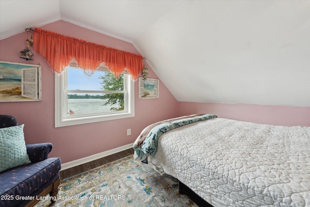 15754 Culver Dr, East Lansing, MI 48823 - bedroom featuring wood finished floors, lofted ceiling, and a water view