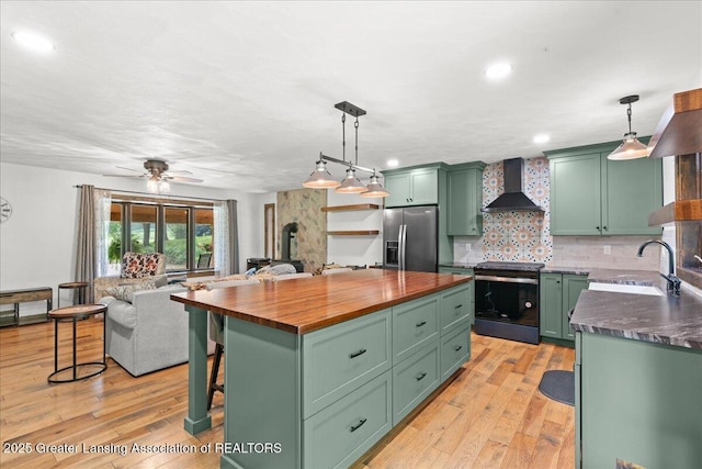 11100 S Bird Rd, Dowling, MI 49050 - kitchen featuring green cabinetry, appliances with stainless steel finishes, wall chimney exhaust hood, wooden counters, and recessed lighting