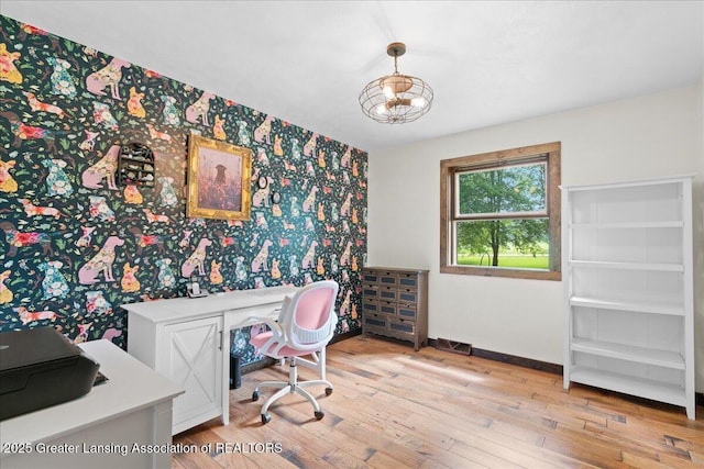 11100 S Bird Rd, Dowling, MI 49050 - home office featuring wallpapered walls, light wood-style flooring, and an accent wall