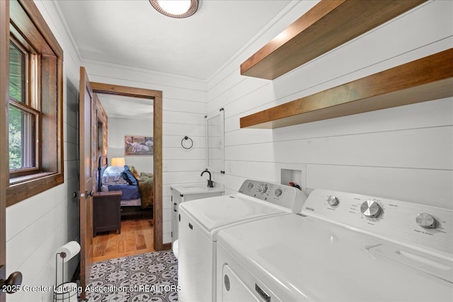 11100 S Bird Rd, Dowling, MI 49050 - laundry room with washing machine and dryer, wood walls, and cabinet space