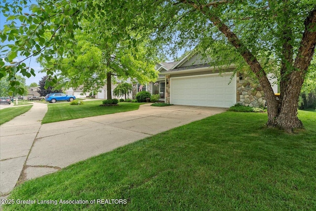 2308 Keller Rd, Holt, MI 48842 - view of front of house with driveway, an attached garage, a front lawn, and stone siding