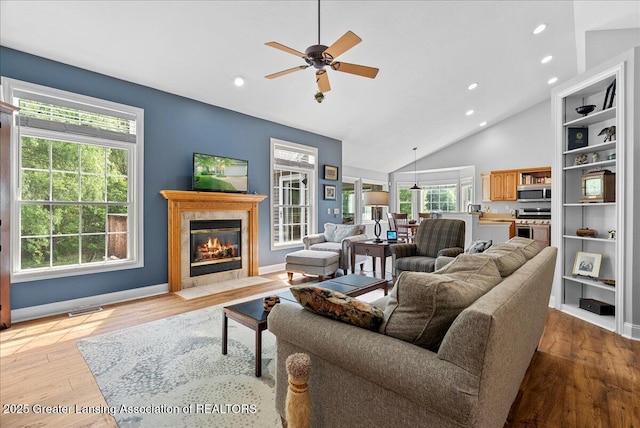 2308 Keller Rd, Holt, MI 48842 - living room with a ceiling fan, light wood finished floors, a fireplace, recessed lighting, and high vaulted ceiling