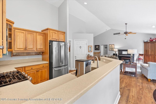 2308 Keller Rd, Holt, MI 48842 - kitchen with freestanding refrigerator, ceiling fan, wood finished floors, glass insert cabinets, and high vaulted ceiling