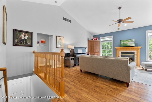 2308 Keller Rd, Holt, MI 48842 - living area featuring light wood-style floors, ceiling fan, high vaulted ceiling, and a fireplace