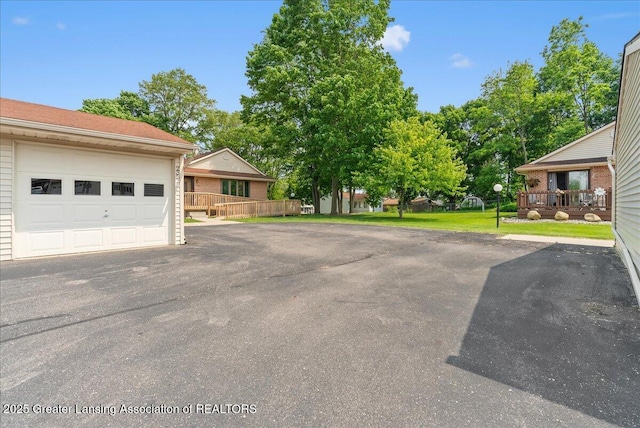 235 Bonnie Brook Dr Unit 1, Charlotte, MI 48813 - view of vehicle parking with a garage and asphalt driveway