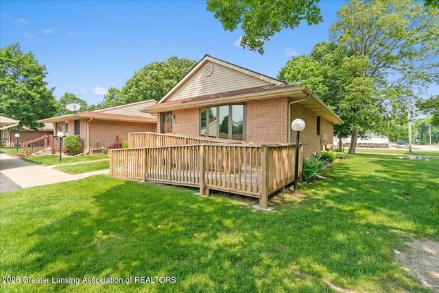 235 Bonnie Brook Dr Unit 1, Charlotte, MI 48813 - view of front facade with brick siding, a deck, and a front yard